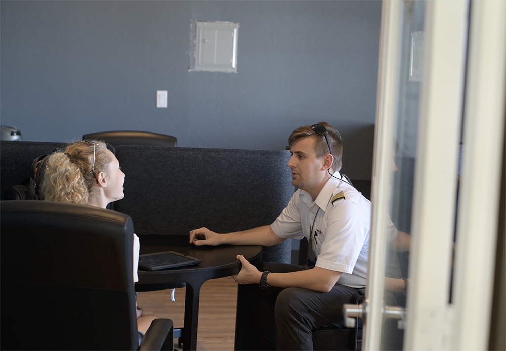 Pilot and student across a table during explanation