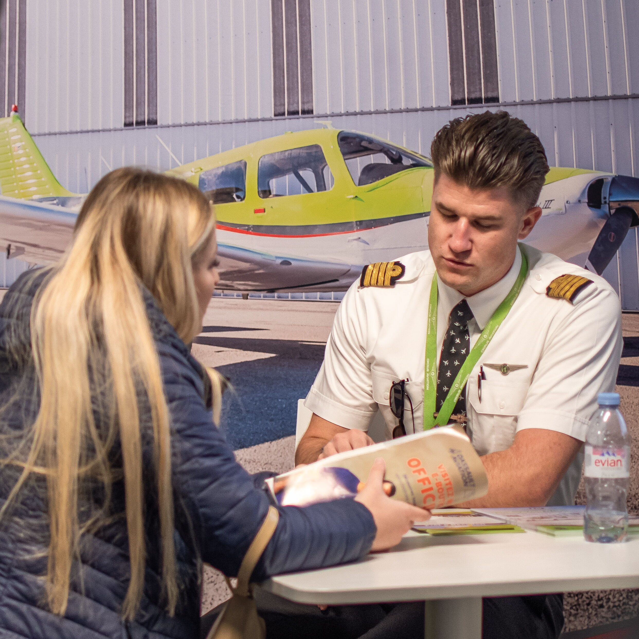 Woman and pilot talking across a table